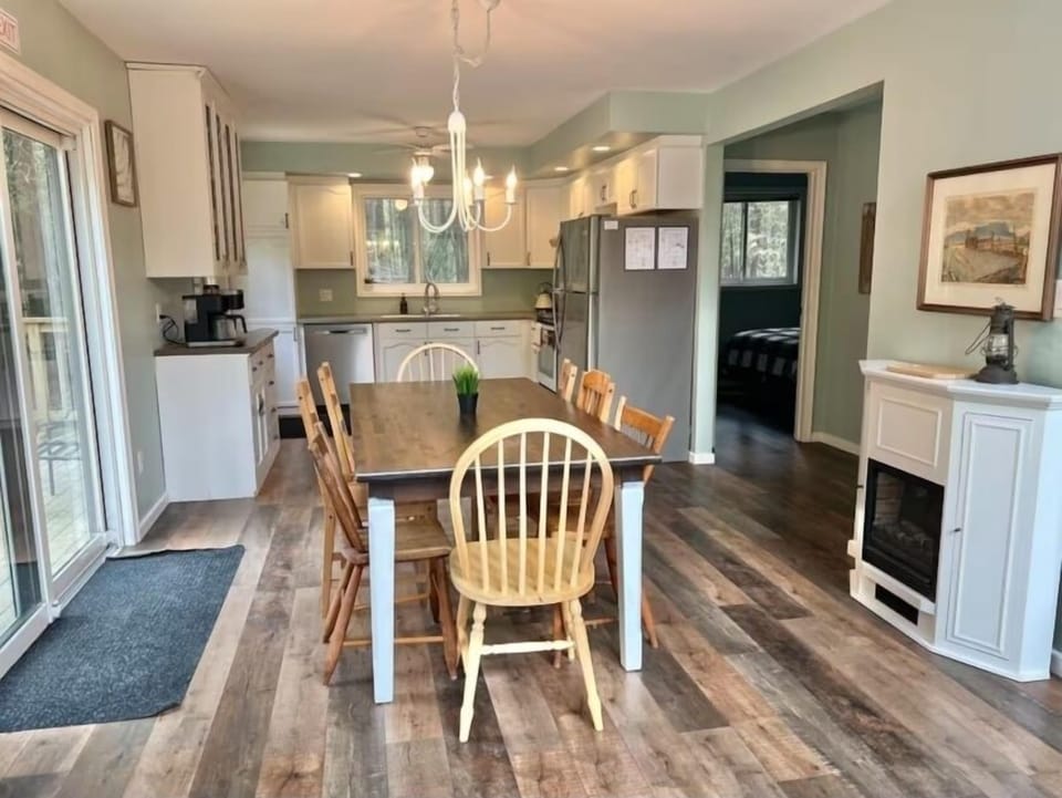 Gather with friends and family around this warm wooden dining table, lit by a cozy chandelier — a welcoming space for shared moments and laughter.