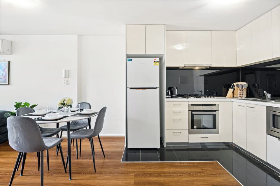 Elegant dining for 4 with plush chairs, warm wood floors & natural light