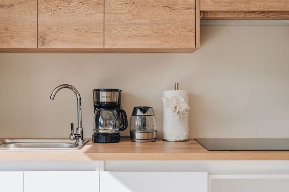 Coffee maker, kettle, and sink detail.