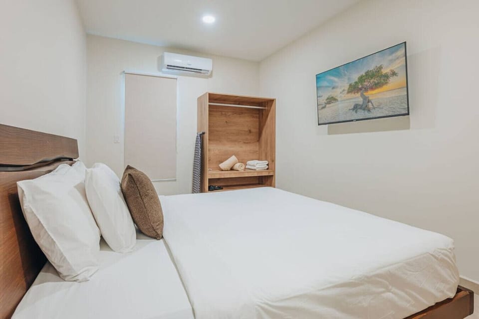 Drift off peacefully on premium bedding; this room also includes a wall-mounted Smart TV.