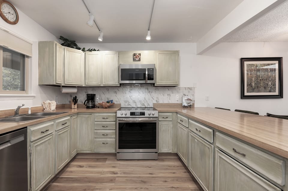 You'll love cooking in this spacious, fully-equipped kitchen with modern appliances and beautiful wood countertops perfect for preparing meals.