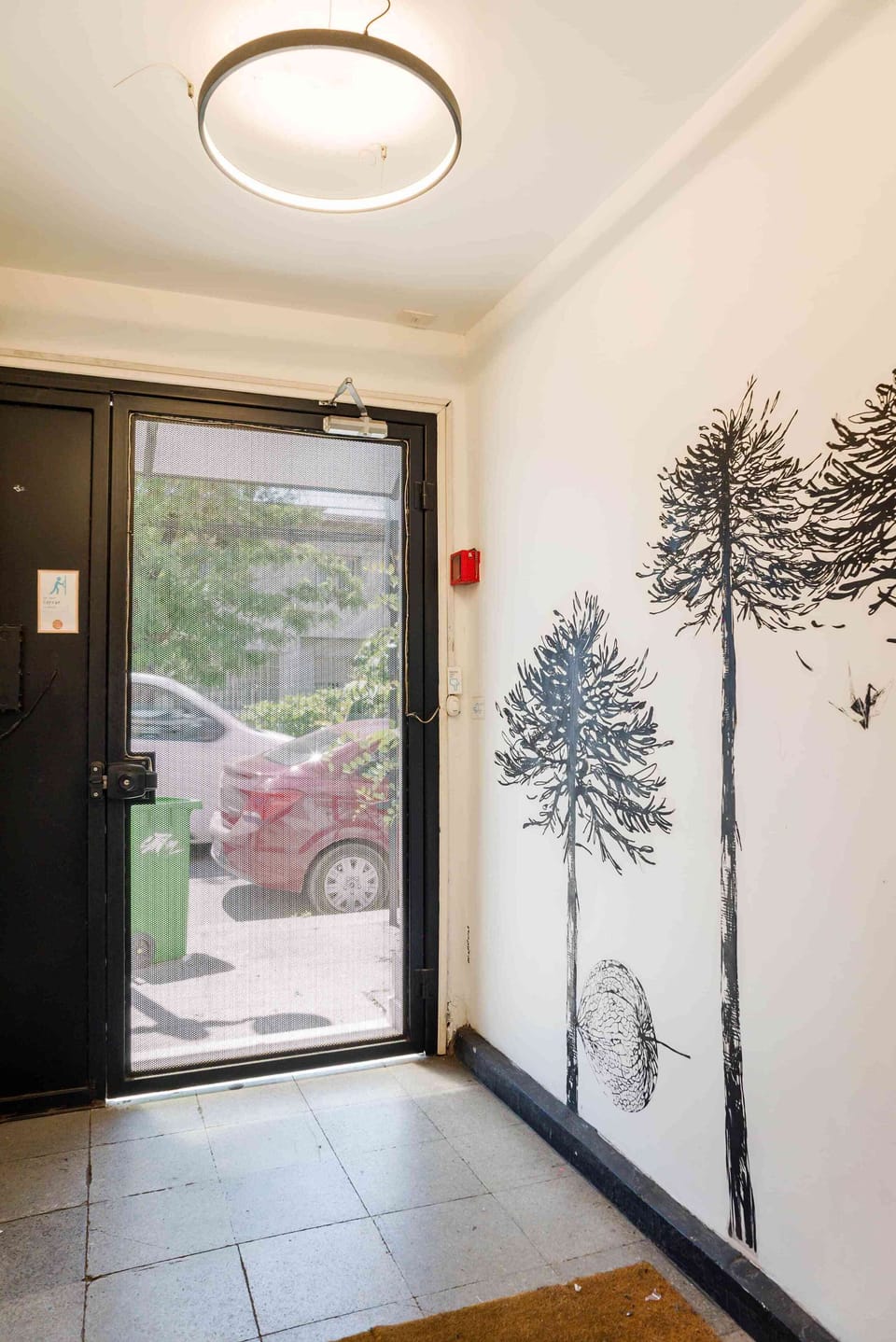 Bright and artistic entrance area with unique wall art and natural lighting.