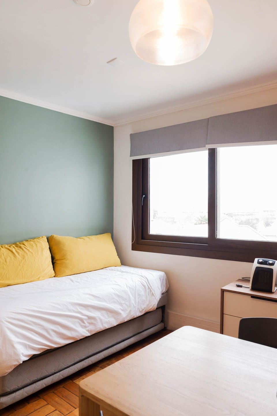 Bright and cozy living space with a comfy daybed and large window for natural light.