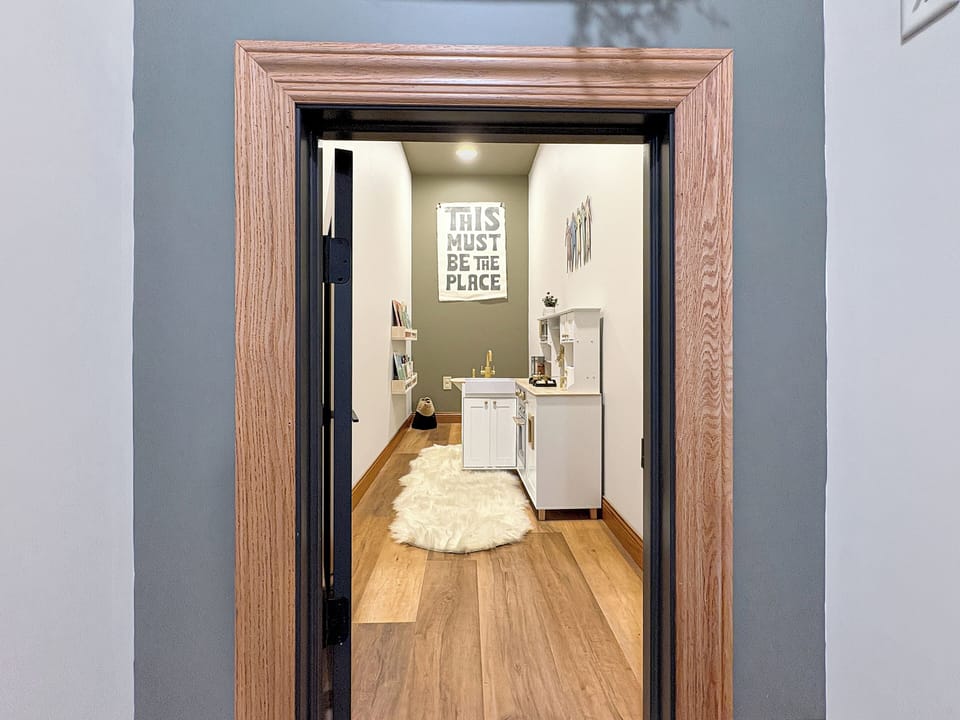 Kids’ playroom with books and a toy kitchen—fun for them, relaxing for you.