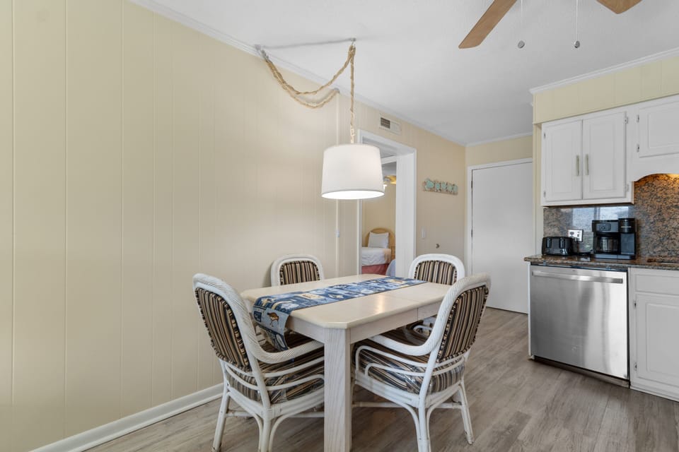 Your bright dining nook features a rope-inspired pendant light and cozy seating for four, perfect for morning coffee or evening meals.
