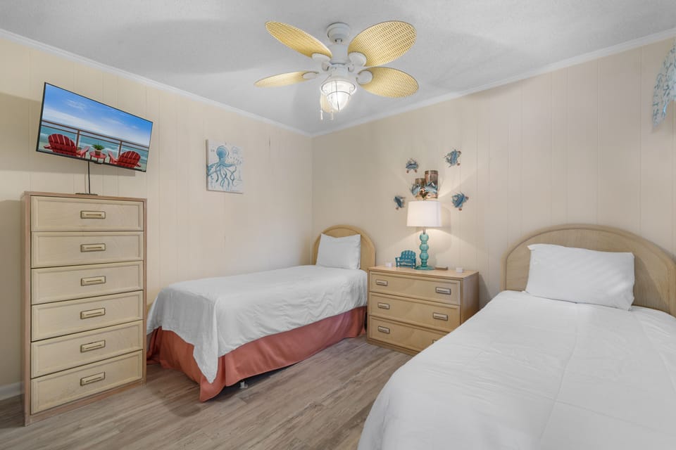 Your coastal-themed twin room offers comfortable beds, charming beach décor, and a ceiling fan to keep you cool during warm nights.