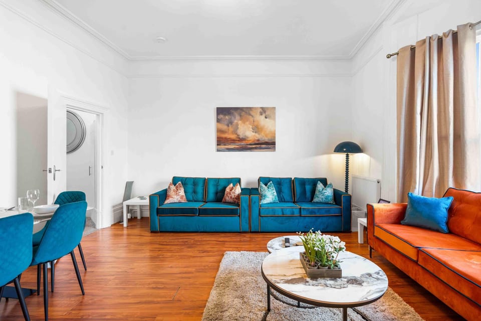 Bright open-plan living and dining area with ttwo sofa beds