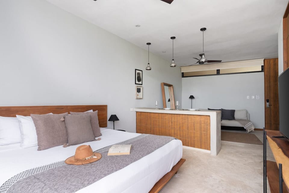 Bright studio with king bed, wooden accents, and modern 50` TV.