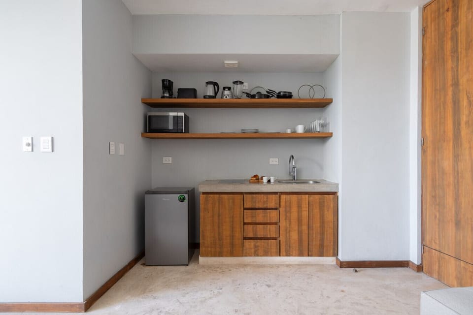Compact kitchen with fridge, coffee maker, cookware, and all essentials.