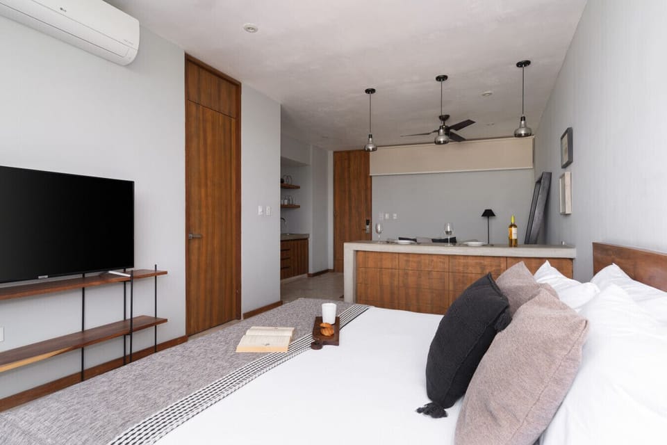 Bright studio with king bed, wooden accents, and a 50` TV for comfort.