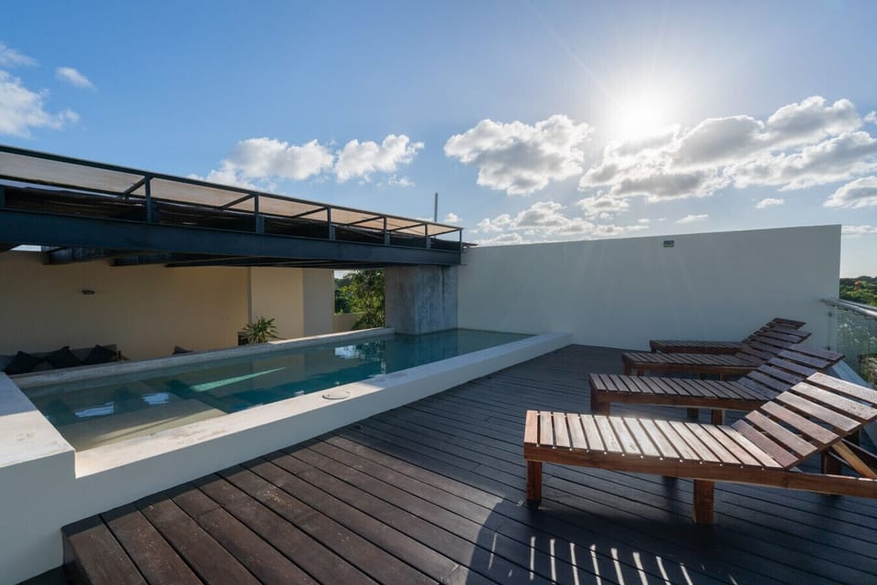 Rooftop pool with loungers and panoramic views—perfect for relaxing or sunbathing.
