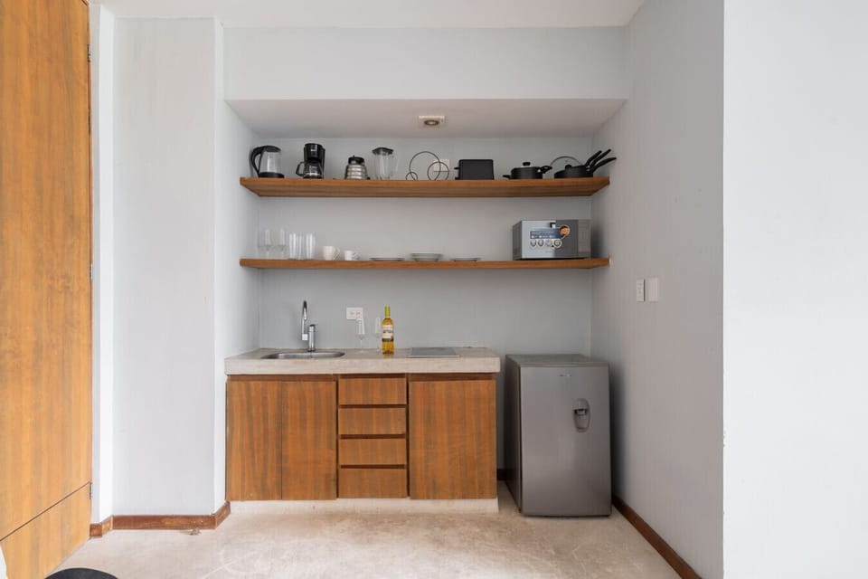 Cozy kitchen with all essentials—fridge, coffee maker, and cookware.