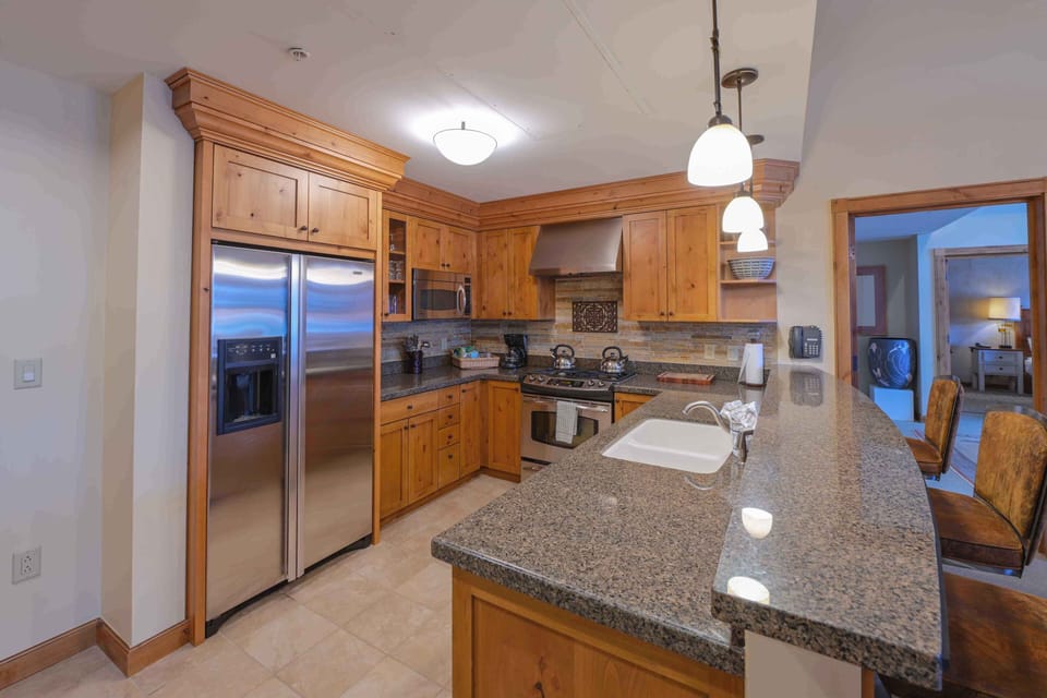 This gourmet kitchen boasts stunning wooden cabinetry paired with modern stainless steel appliances, perfect for culinary enthusiasts.
