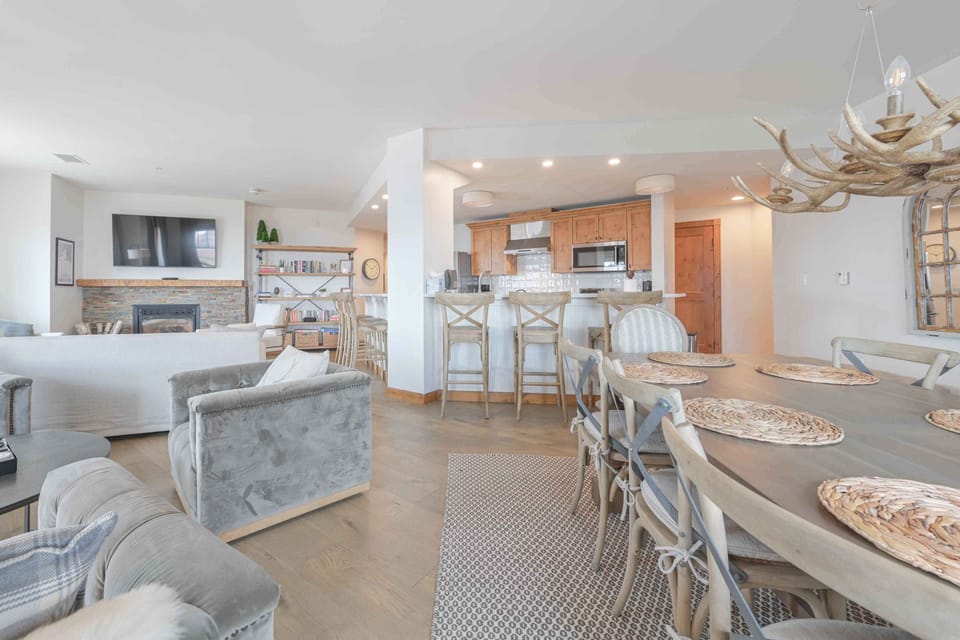 Elegant dining area featuring a long wooden table, inviting meals with family and friends against a backdrop of mountain views.
