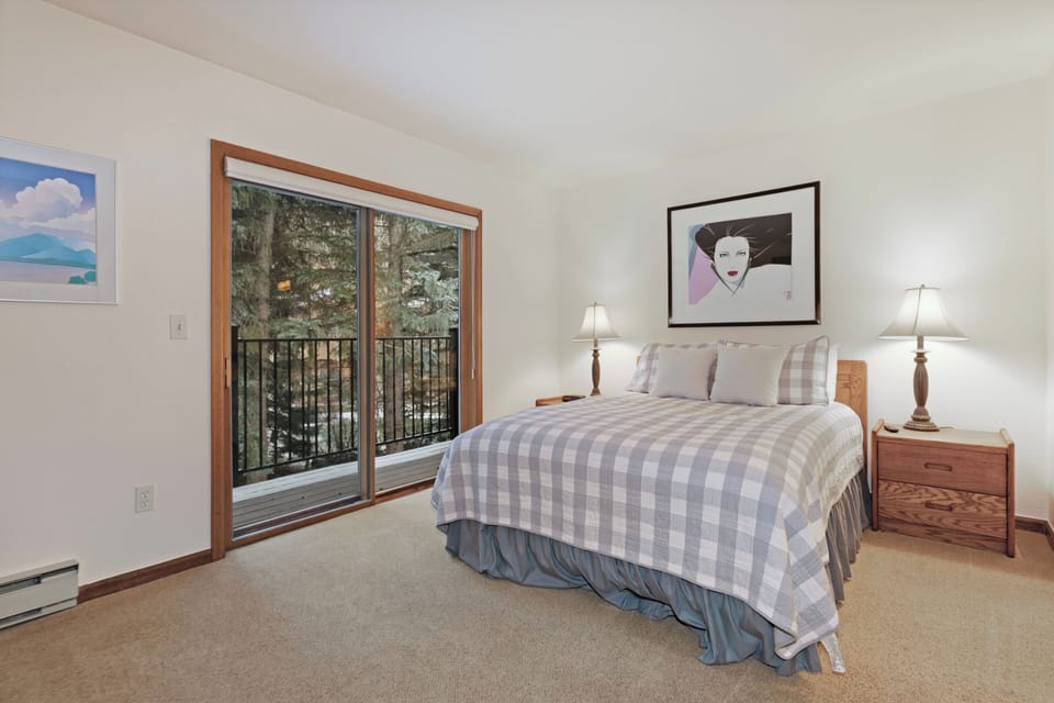 Your comfortable bedroom features a cozy queen bed and private balcony where you can step outside to enjoy the peaceful forest surroundings.
