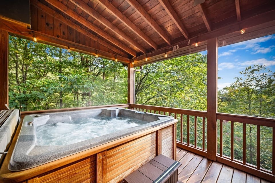 Slip into the warm, bubbling hot tub on a covered deck surrounded by treetops & mountain air. As the forest stretches out before you, unwind to the sounds of nature, glowing string lights, & peaceful views that turn every soak into a relaxing escape.