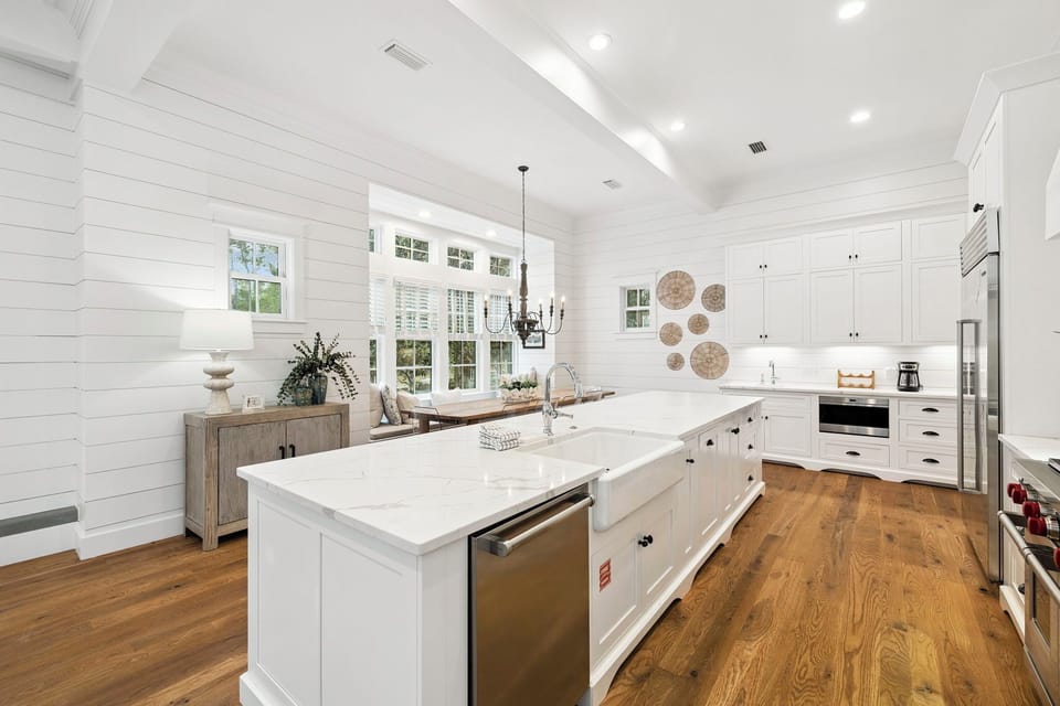Step into your chef's dream kitchen, where farmhouse charm meets modern convenience. Crisp white shiplap walls, gleaming marble counters, and warm wood floors create a bright, welcoming space for cooking and gathering.