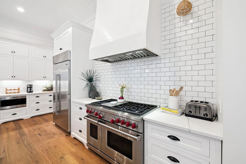 Your gourmet kitchen awaits with a professional-grade gas range, gleaming white subway tile backsplash, and modern appliances—perfect for cooking memorable vacation meals together.
