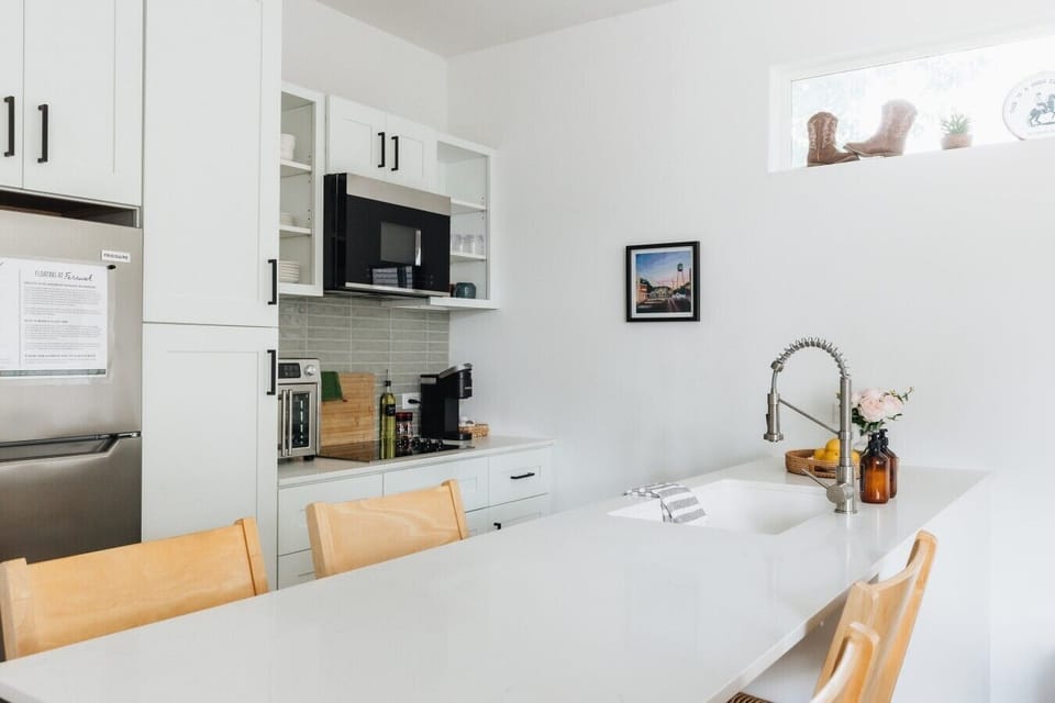 Fully loaded with mid-size fridge & freezer, 4 burner induction cooktop, microwave, dishwasher, and countertop multi-oven
