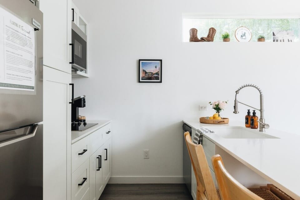 Fully loaded with mid-size fridge & freezer, 4 burner induction cooktop, microwave, dishwasher, and countertop multi-oven