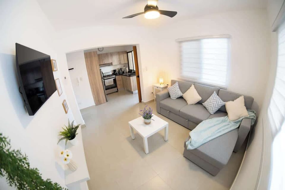 - Spacious living area connecting kitchen and lounge seamlessly
- Cozy seating with smart TV fast internet and natural light
- Functional layout designed for comfort long stays and easy living