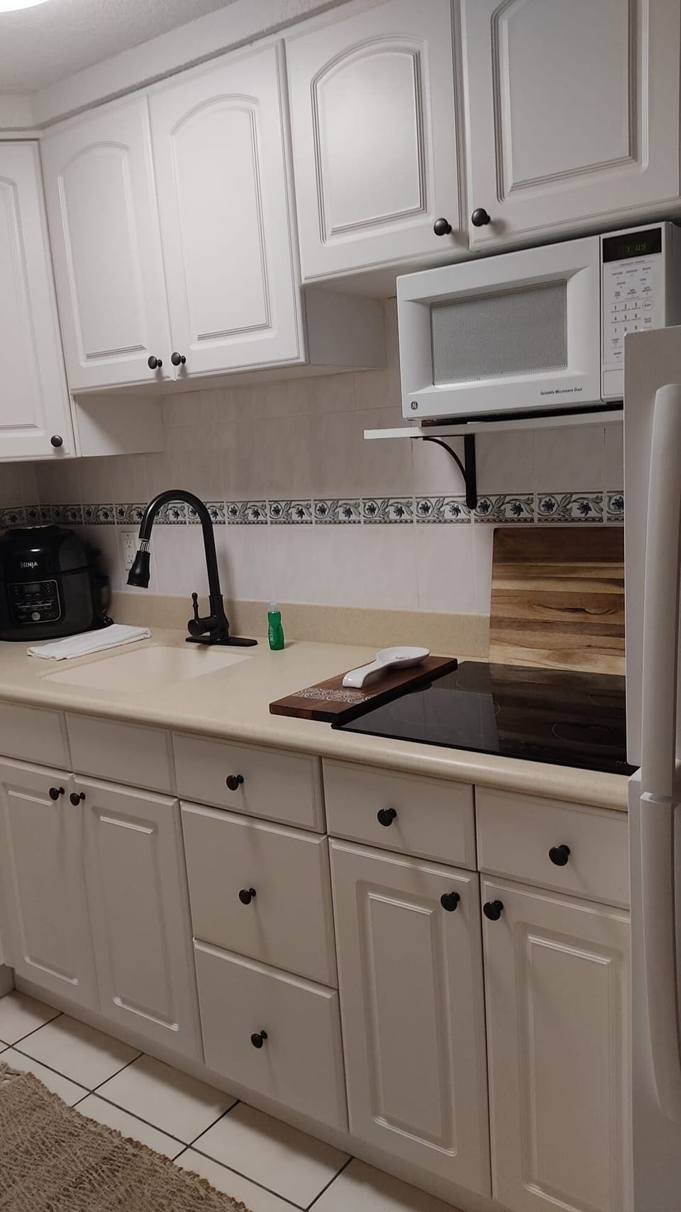 - Kitchenette with microwave, fridge, coffee maker, and storage
- White cabinets and counter space for simple meals
- Practical setup ideal for snacks, breakfast, and quick dining 