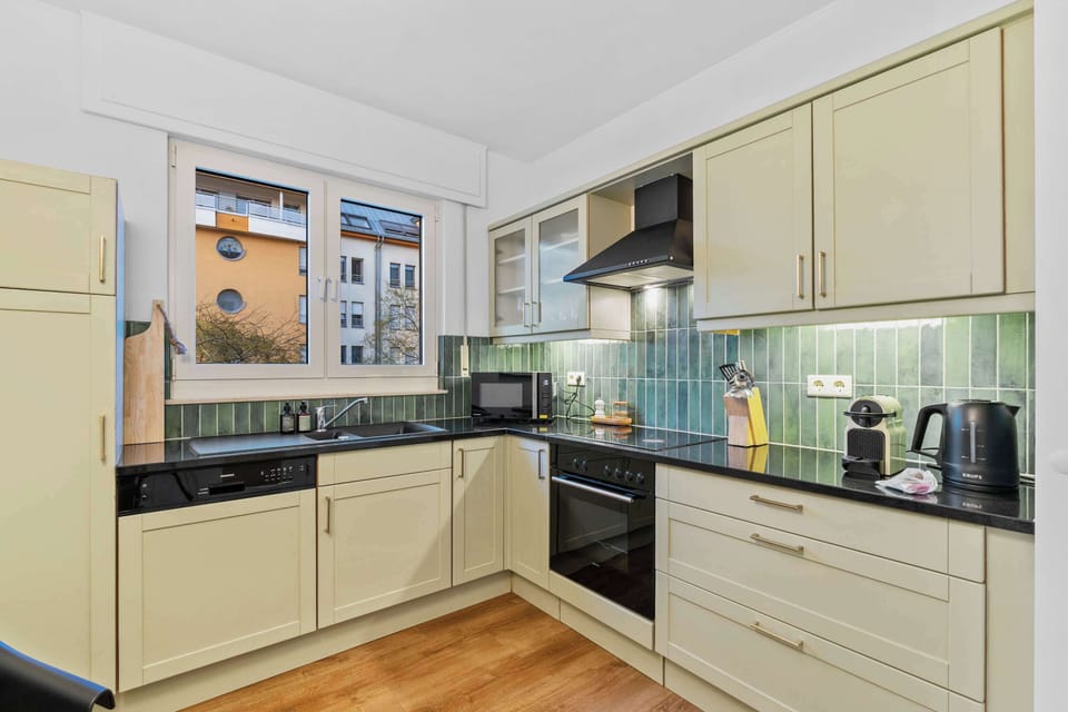 Stylish and functional kitchen with modern appliances including a dishwasher, oven, stovetop, microwave, and Nespresso machine. Perfect for cooking comfortably during short or extended stays.
