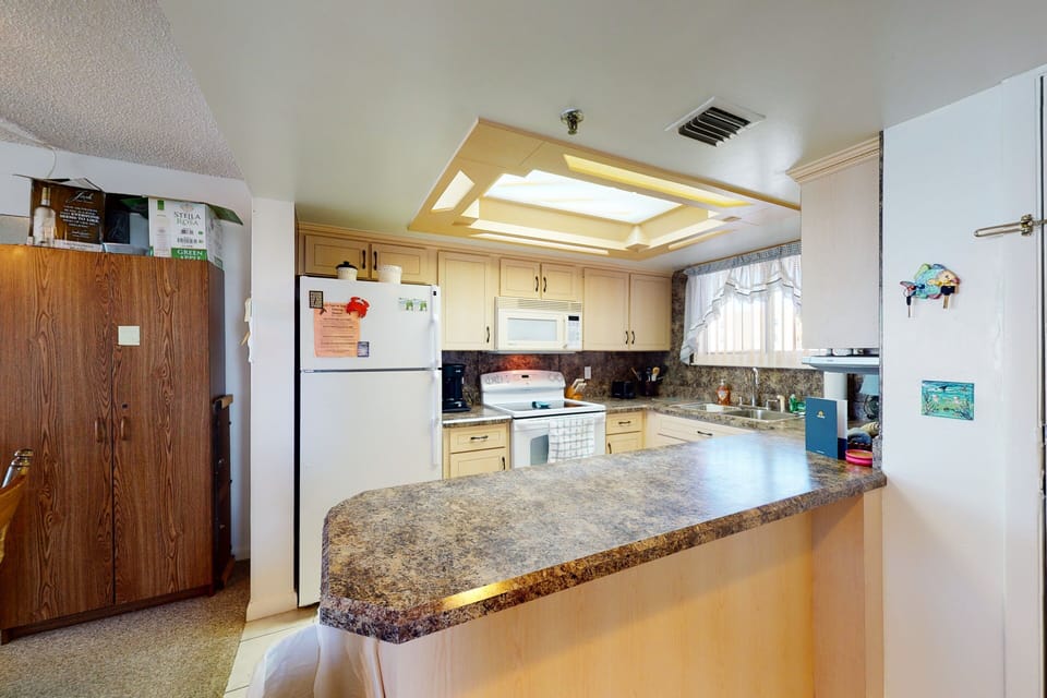 This beach stay kitchen offers full appliances, ample counter space, and a spacious breakfast bar. Ideal for cooking, dining, and gathering after a relaxing day by the ocean.