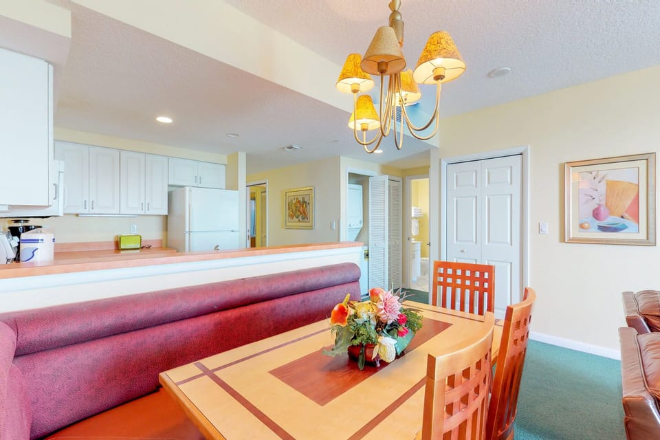 Gather in this bright coastal dining space with comfortable seating and an open kitchen layout. Ideal for a relaxed beach stay, it's perfect for meals, planning seaside outings, and unwinding after beach days.