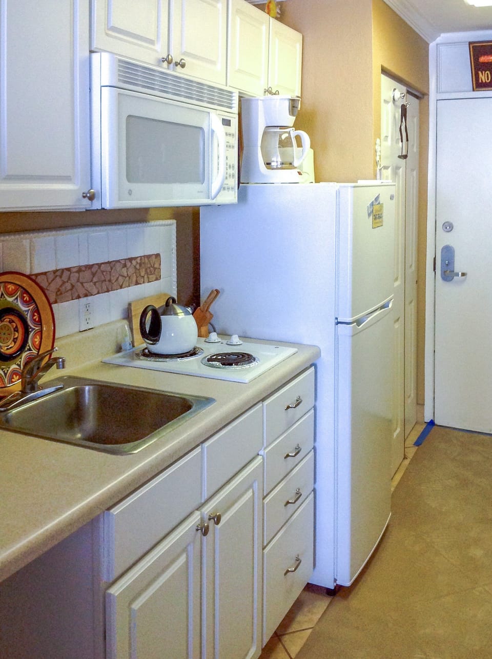 Compact and efficient beach stay kitchenette with essential appliances, perfect for preparing simple meals during your beach vacation. Enjoy convenience, coastal comfort, and more time to relax by the ocean.