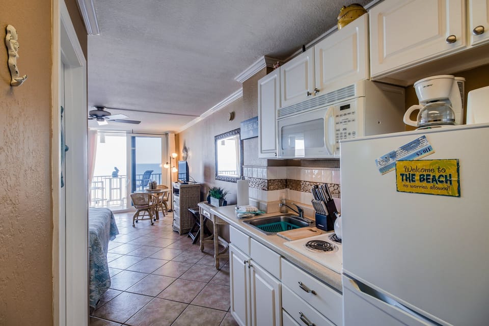 Functional beach stay kitchen with full-size appliances and coastal touches, opening to a bright living and dining area. Enjoy easy meals before beach days, plus ocean views and a relaxing seaside vacation atmosphere.