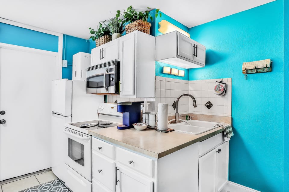 Cook and dine with ease in this bright beach stay kitchen featuring modern appliances, clean finishes, and coastal accents. A welcoming space for easy meals before or after your beach adventures.