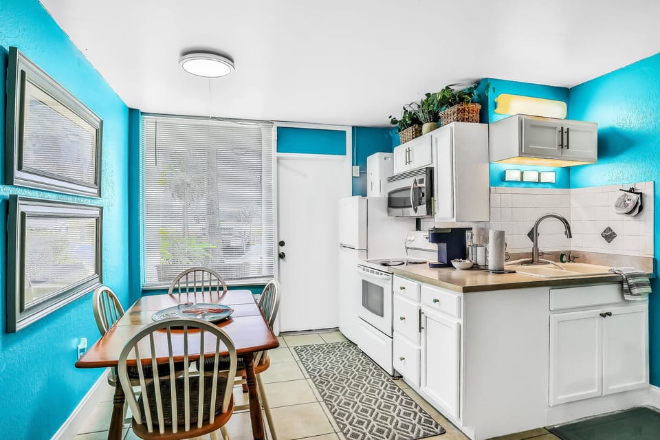 Enjoy easy coastal living in this bright beach stay kitchen and dining area, featuring modern appliances, ample counter space, and a cozy table—perfect for meals before or after a day at the beach.