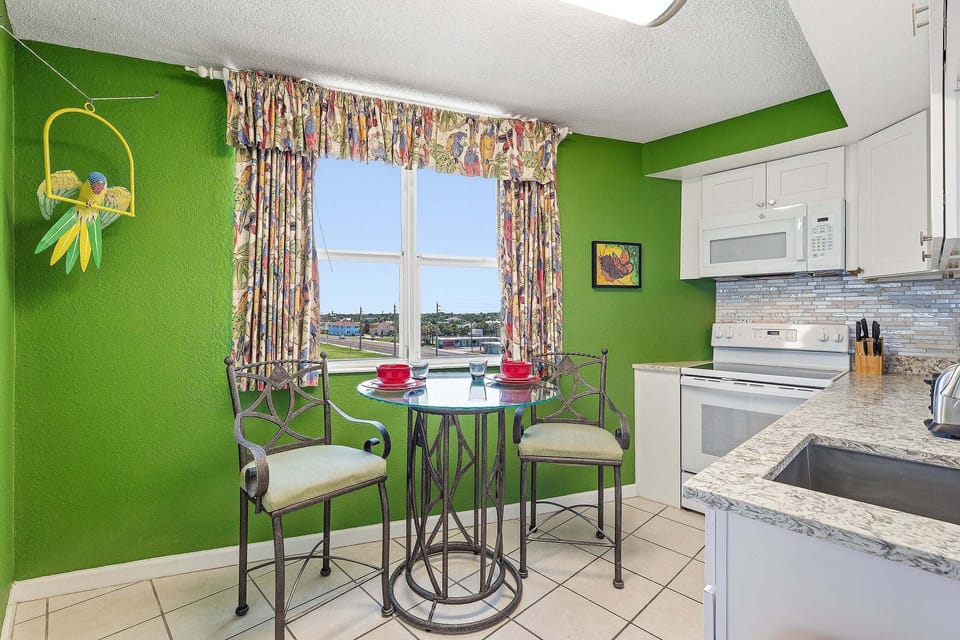 Start your day in this bright coastal kitchen featuring modern finishes, full-size appliances, and a cozy breakfast nook by the window. A welcoming space to enjoy meals during your relaxing beach stay.