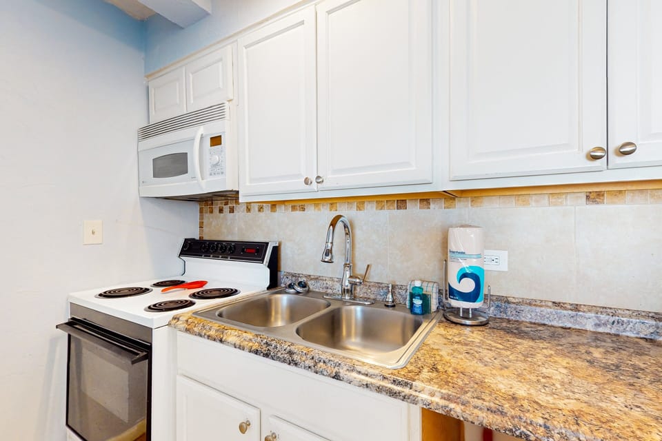 Bright beach-stay kitchenette featuring full appliances, spacious counters, and essentials for easy coastal meals—perfect for relaxing after a sunny day by the shore.