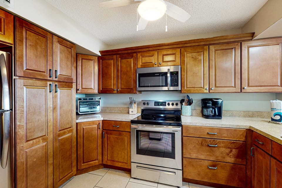 Cook with ease during your beach stay in this spacious, fully stocked kitchen featuring modern appliances, ample counter space, and warm cabinetry—perfect for fueling your seaside adventures.