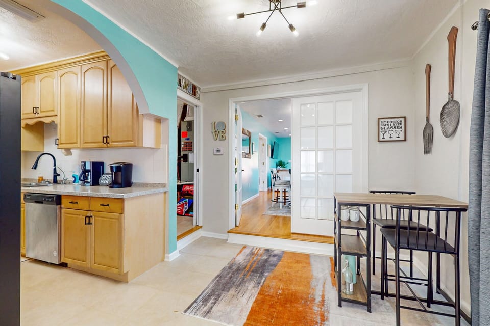 This open kitchen and dining nook features modern appliances, beach-inspired colors, and an easy flow to living spaces—perfect for casual meals and relaxing moments during your comfortable beach stay.