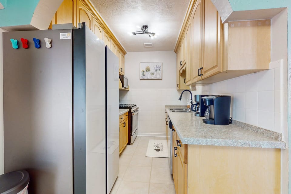Prepare meals with ease in this bright, fully equipped kitchen featuring modern appliances, ample counter space, and coastal charm—perfect for fueling your beach stay before or after fun-filled days by the shore.