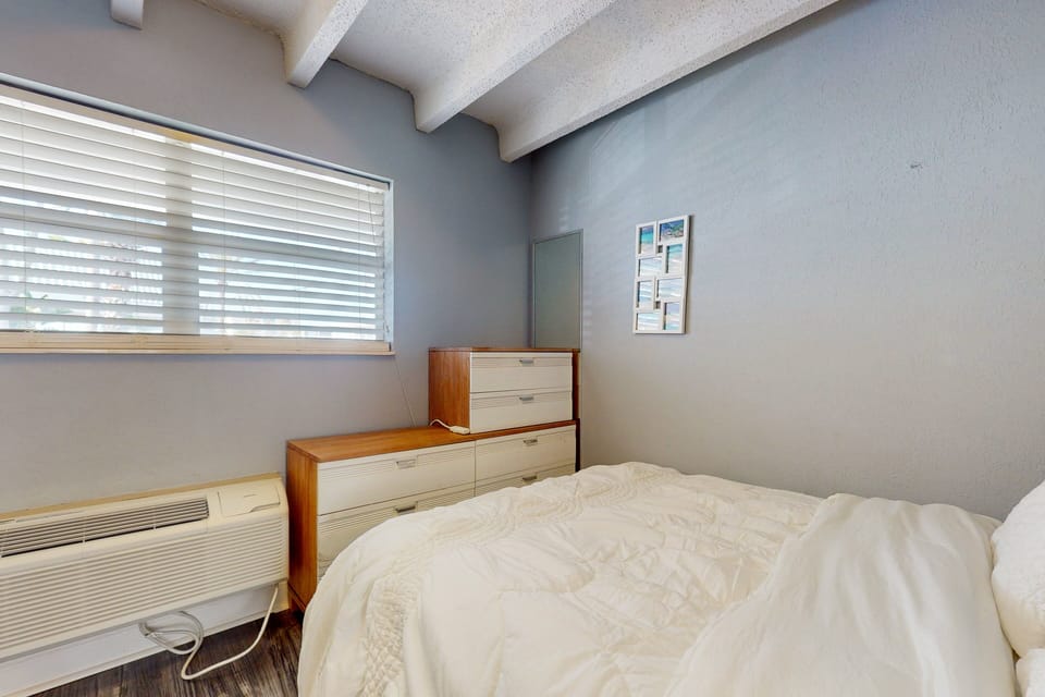 Unwind in this calm coastal bedroom featuring soft linens, natural light, and a serene beach stay vibe. Designed for comfort after sun-filled days, it's the perfect space to relax and recharge by the coast.