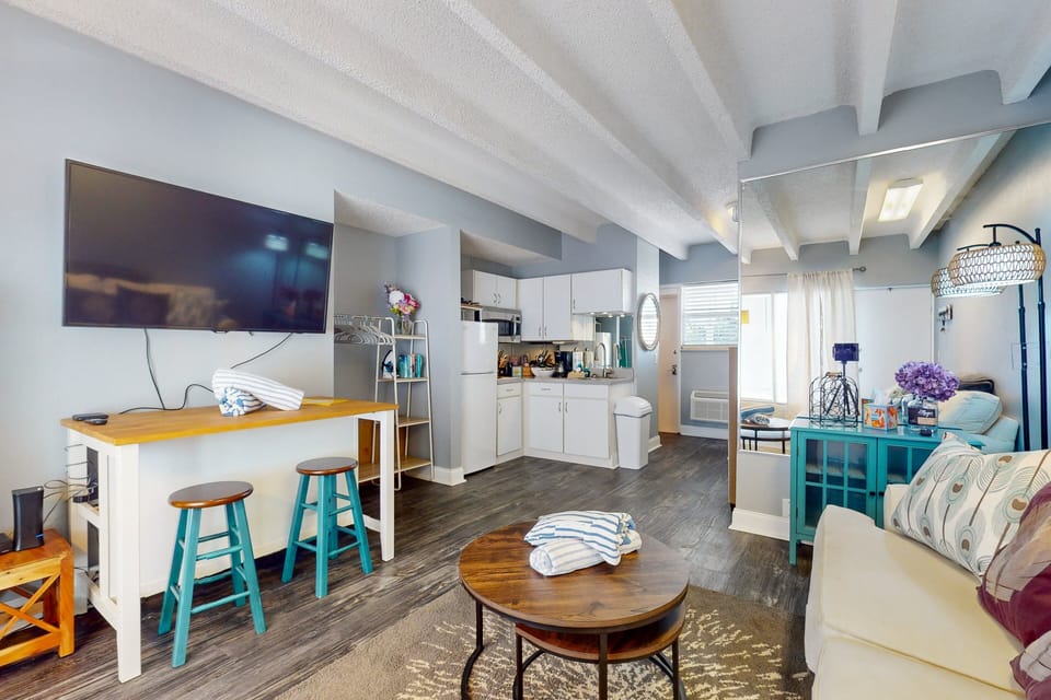 This open coastal studio offers a comfortable living area, dining space, and kitchenette, ideal for a relaxing beach stay. Bright and inviting, it's perfect for unwinding after days spent enjoying the sun and shore.