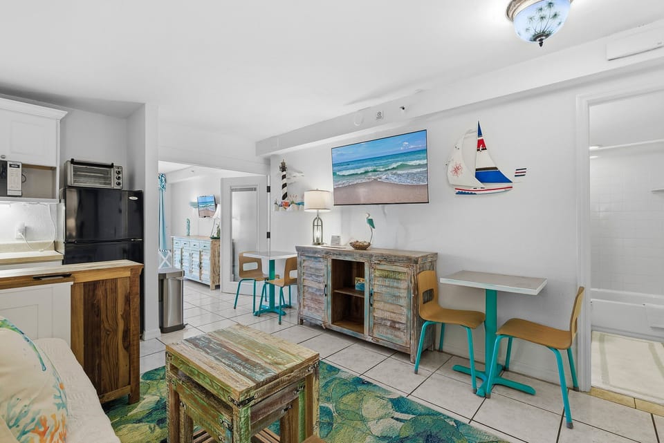 This bright coastal living and dining area features beach-inspired décor, a comfortable seating space, and a casual dining nook. Ideal for a laid-back beach stay, offering comfort and convenience after fun-filled days by the ocean.