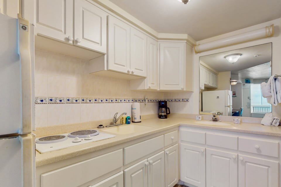 This fully equipped beach stay kitchenette offers a stovetop, coffee maker, sink, and ample storage—perfect for preparing simple meals and snacks during your relaxing coastal getaway.