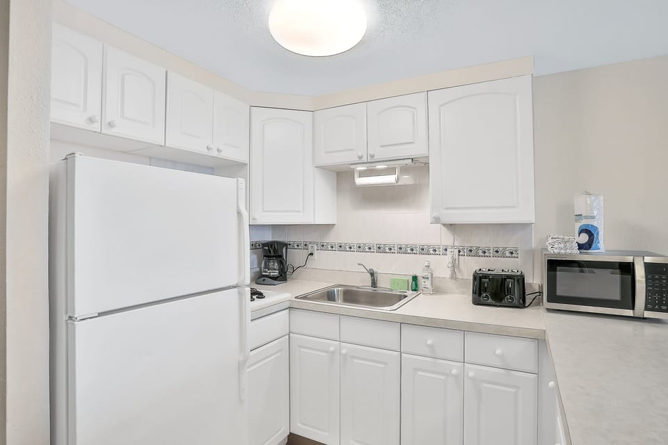 Convenient kitchenette with full fridge, microwave, and essentials—perfect for easy meals during your beach stay. Clean, bright, and ready to support relaxing oceanside living.