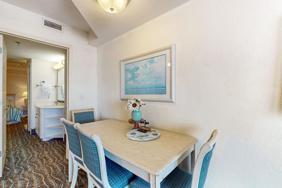 Enjoy relaxed beach stay meals in this charming dining nook, featuring coastal décor and easy access to the bedroom and vanity—perfect for unwinding after a day by the ocean.