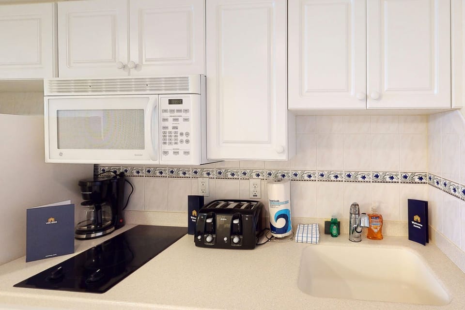 Cozy beach stay kitchenette with microwave, stovetop, and essentials. Enjoy ocean-area convenience and prep meals steps from the shore in this clean, well-equipped space.