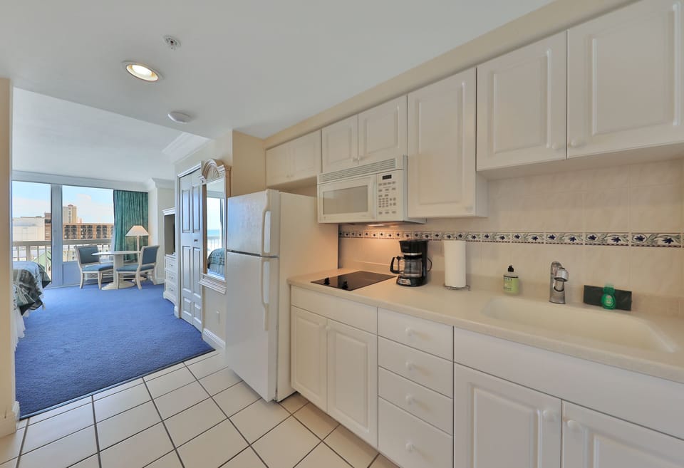 Convenient beach stay kitchenette featuring full-size appliances, ample storage, and easy access to the oceanview living area—perfect for quick meals before hitting the sand and surf.