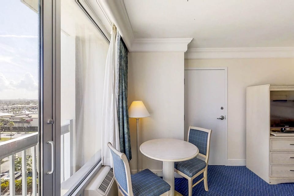 Bright dining corner with large windows showcasing stunning city and distant beach views—perfect for enjoying meals during your relaxing beach stay.