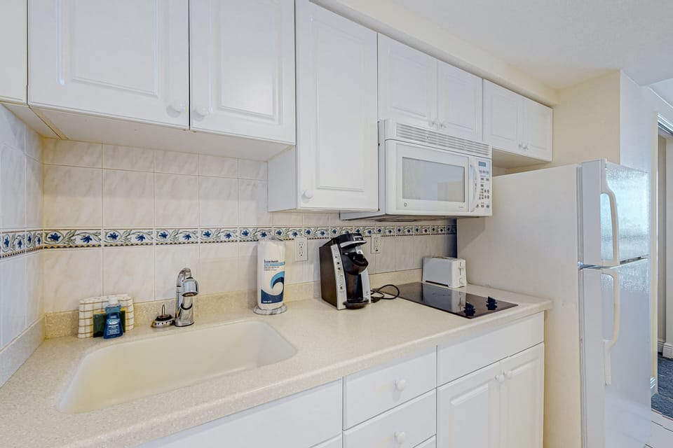 Bright, beach-ready kitchenette with essential appliances, perfect for prepping meals during your seaside stay. Clean, spacious, and ideal for extended oceanfront getaways.