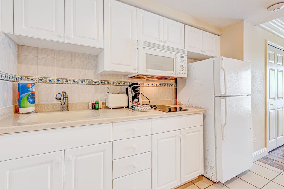 Convenient beachfront kitchenette with essentials—perfect for preparing quick meals during your beach stay. Clean, bright space with cooktop, microwave, and fridge for added vacation comfort.