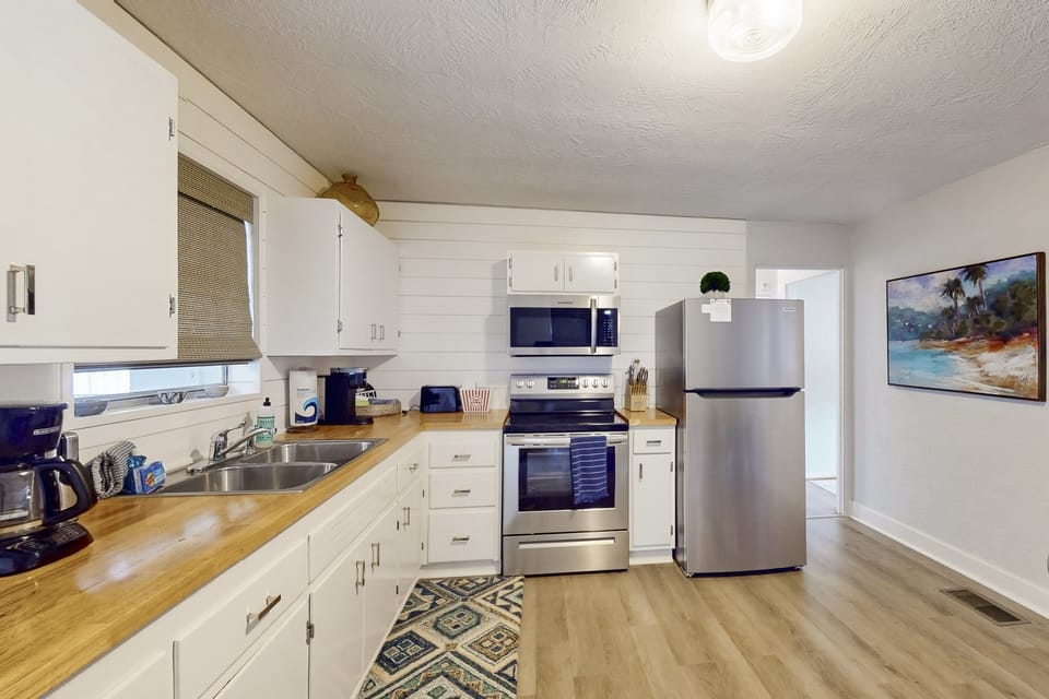 Spacious, beach-style kitchen with modern appliances, ample prep space, and coastal charm—ideal for cooking, gathering, and enjoying easy meals during your laid-back beach stay.